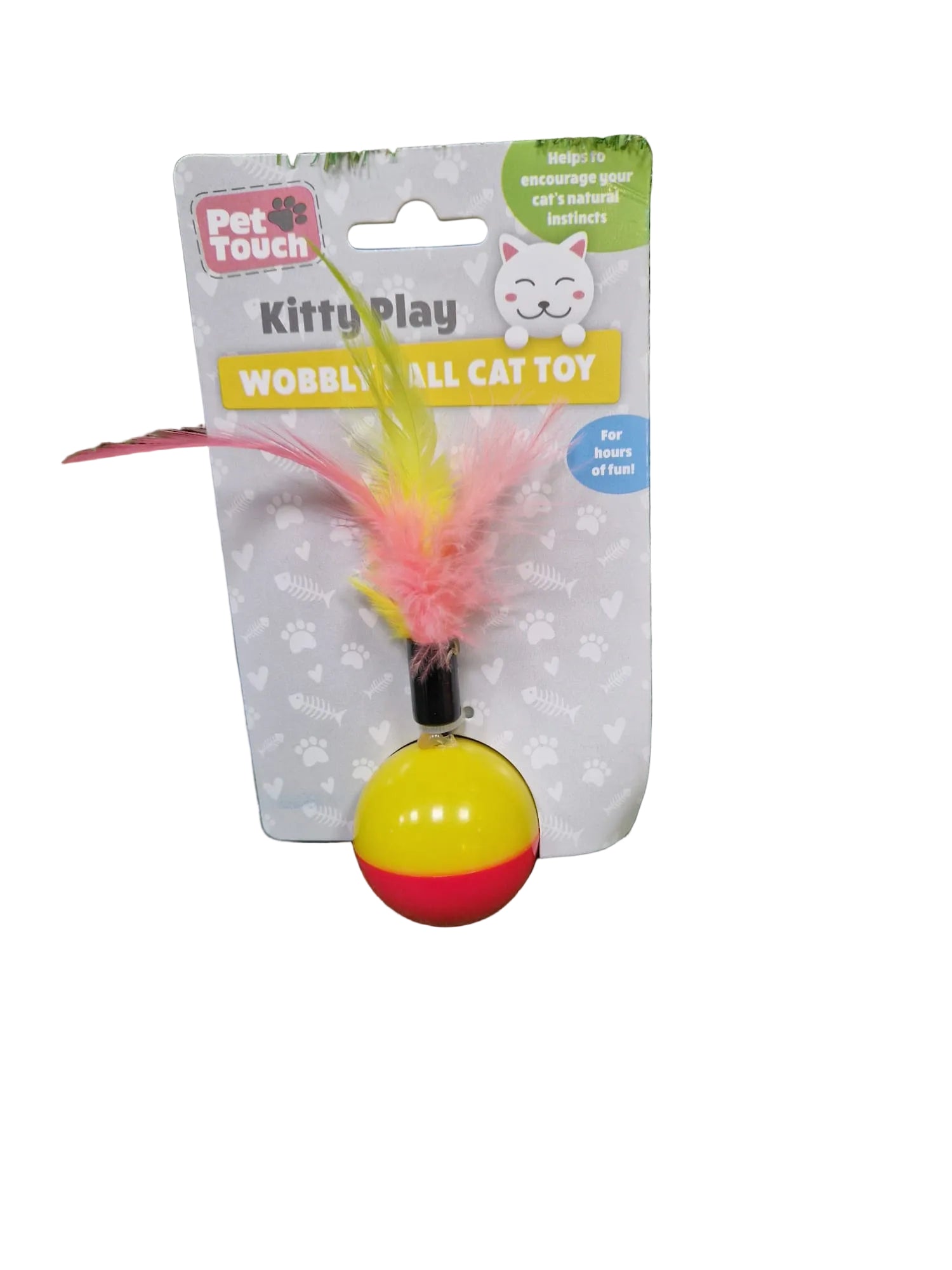 Cat toy with wobbly ball and feathers on a green grass background